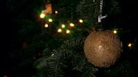 Golden Christmas Ball With Colored Dots And Lights In Background